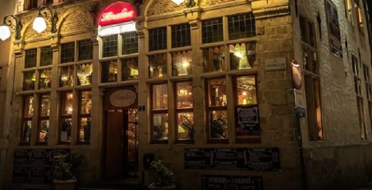 De gevel van Amadeus Gent 2 bij het Belfort bij valavond, met het rode Amadeus-lichtbord boven de deur en warm verlichte ramen