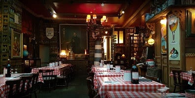 Rood-wit geruite tafels onder een schilderij en warme lampen in Amadeus Antwerpen 2