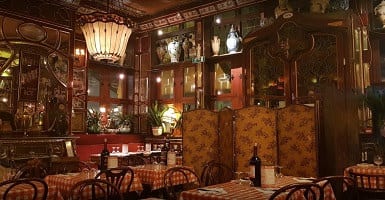De houten art-nouveau zaal van Amadeus Gent 2 met lange rijen gedekte tafels