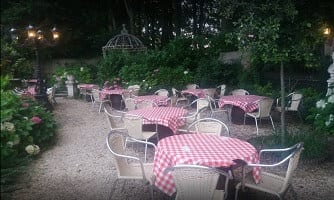 Het buitenterras van Amadeus Lozer met geruite tafelkleedjes tussen het groen